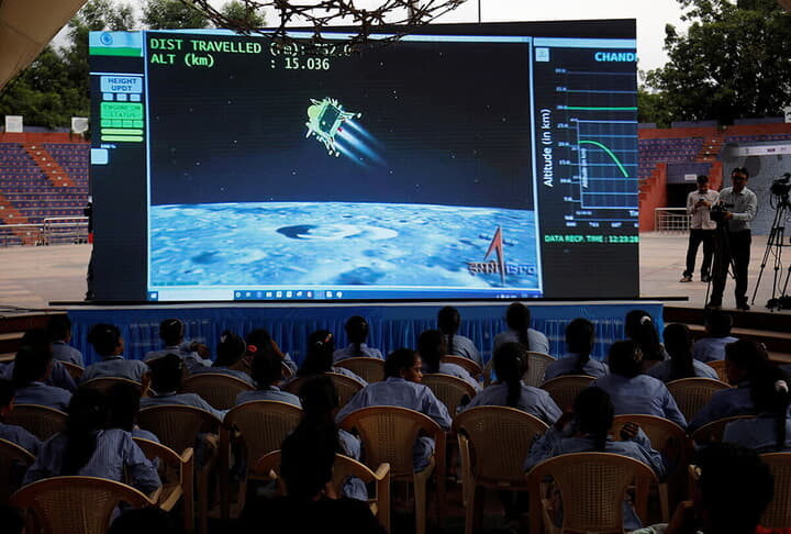 スクリーンの前で「チャンドラヤーン3号」月面着陸の瞬間を待つ人々