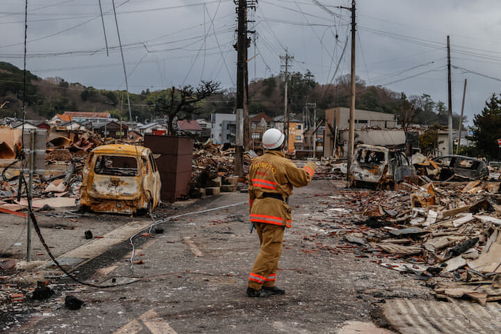 地震で破壊された石川県輪島市で生存者を探す消防士