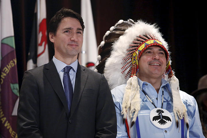 先住民族の代表と並ぶトルドー首相