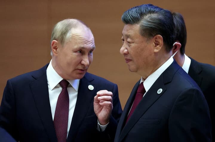 上海協力機構で会話するプーチンと習近平