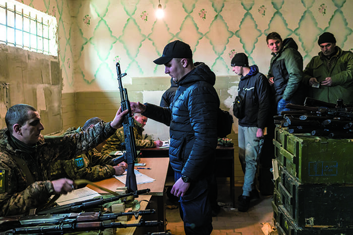 ロシアが侵攻を開始した2月24日、ウクライナ政府は希望する市民に武器を供与すると発表した。その翌日、首都キーウ近郊ファスティフの武器保管施設で銃を受け取る人々（ブレンダン・ホフマン撮影）