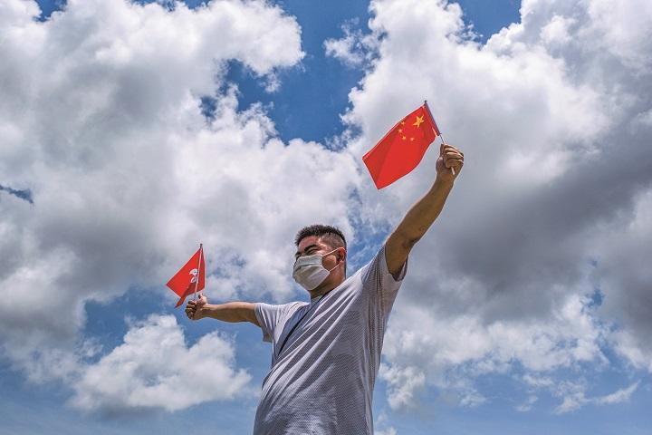 中国旗と香港旗を持つ親中派の香港人