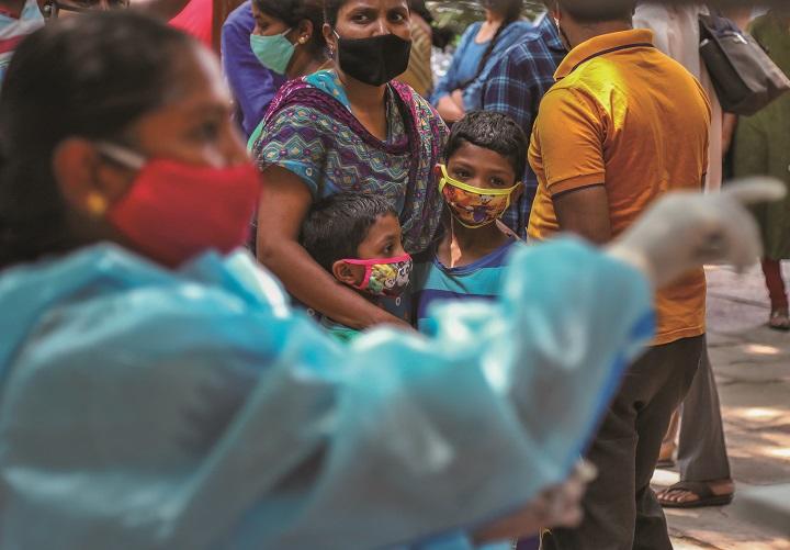 ワクチン接種の列に並ぶインドの親子
