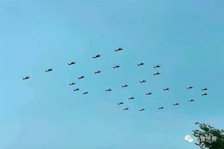 「100」の字の編隊を組んで飛ぶ中国の攻撃ヘリ
