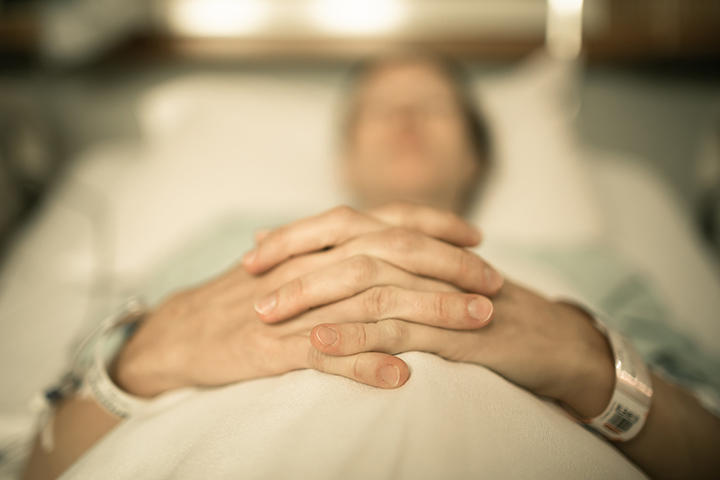 病院のベッドに横たわる女性（イメージ）