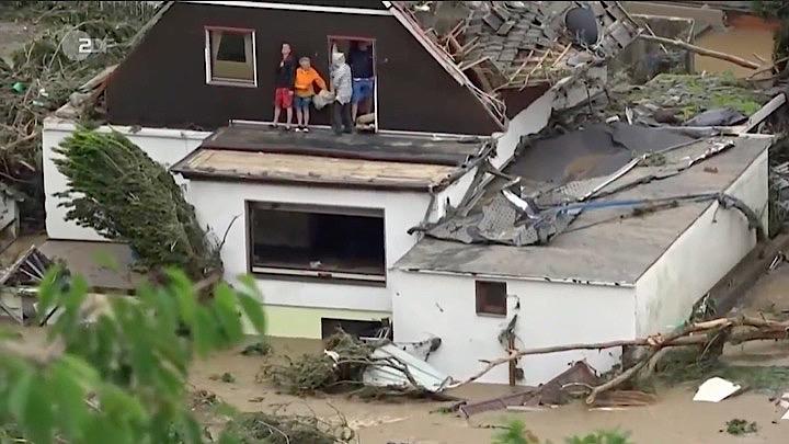 1階が土砂に埋もれた建物から救助を待つ人