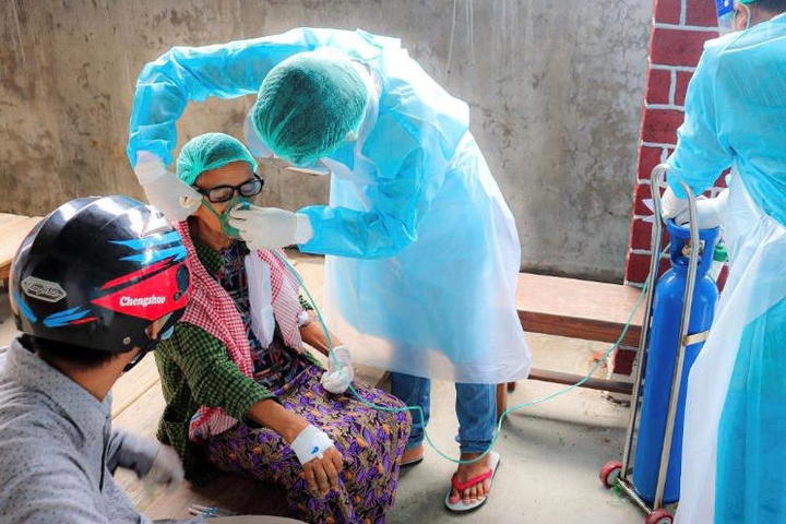 ミャンマー北部ザガイン管区で患者にマスクを付けるボランティア従事者