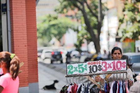 南米ベネズエラで米ドル価格で衣料品を売る女性
