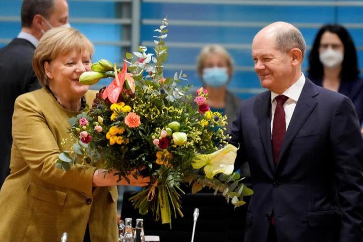 次期ドイツ首相候補のオラフ・ショルツから花束を受け取るメルケル