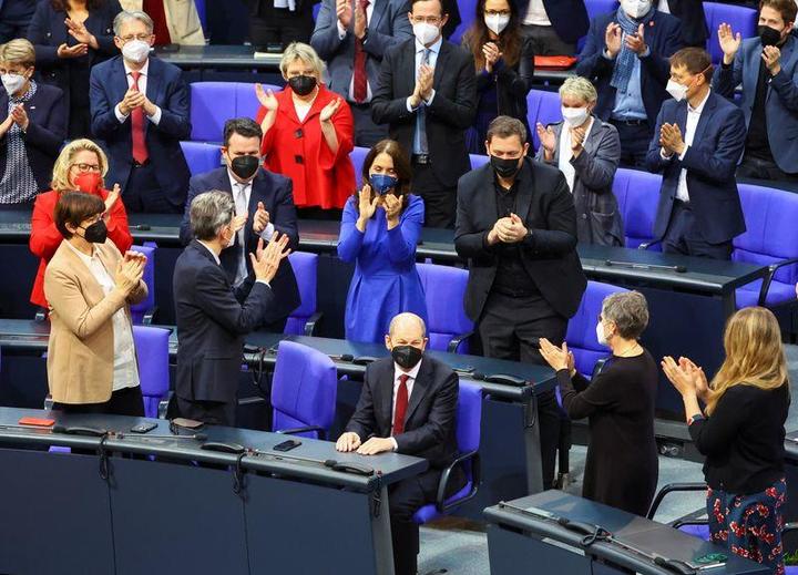 ドイツ下院議場で拍手を受けるオラフ・ショルツ新首相（中央）