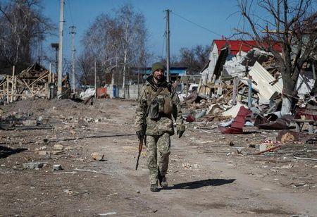 キエフ州東部で破壊された村を歩くウクライナ軍兵士