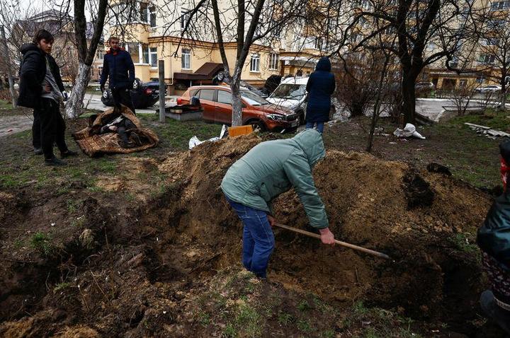 ロシア軍に殺害されたとされる住民を埋葬するブチャの人々