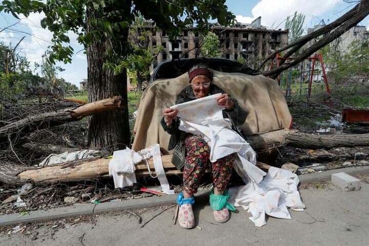 マリウポリの破壊された住宅前に座る住民