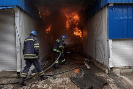 ロシアの攻撃を受けた市場で消火活動に当たる人々