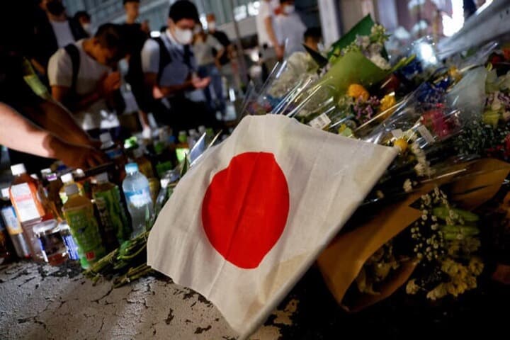 安倍晋三元首相の銃撃現場に手向けられた花と日本国旗