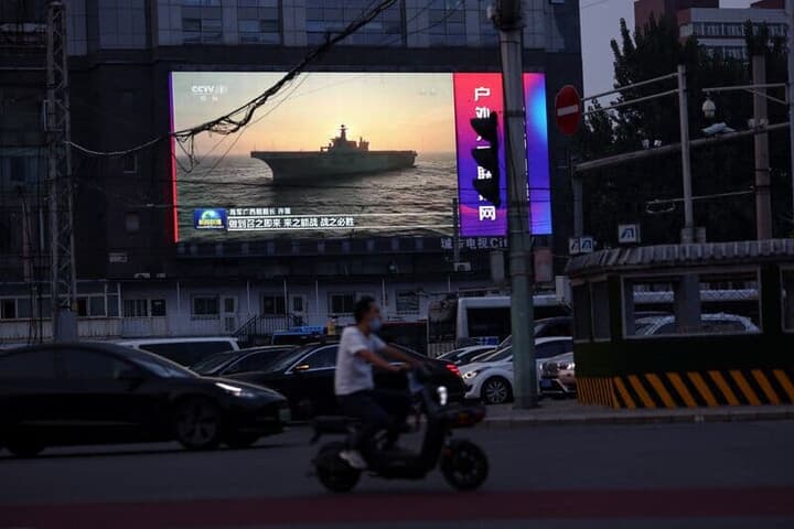 北京の街頭でモニターに映し出された軍事演習の映像