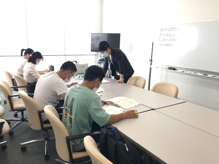 4人のベトナム人留学生に講義を行う、神戸国際大学の瀬戸口達也さん