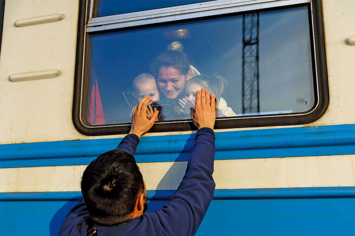 ウクライナ西部の大都市リビウの鉄道駅でポーランド行きの列車に乗り込んだ家族と別れを惜しむ男性