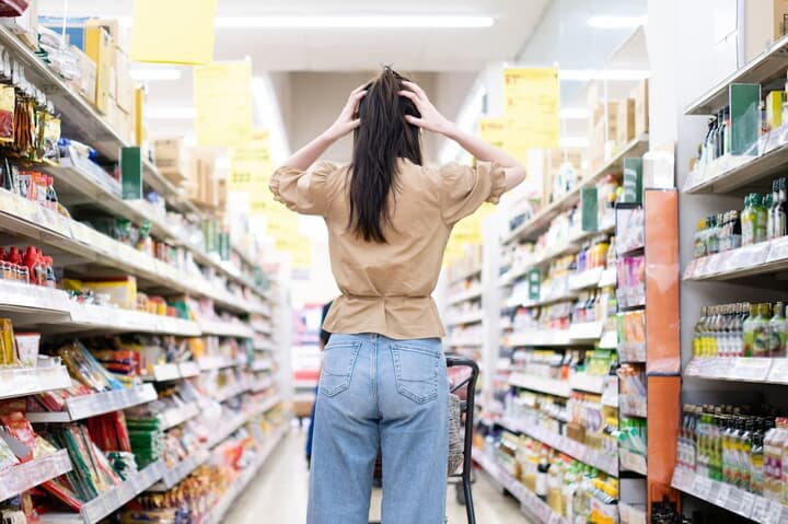 スーパーマーケットで頭を抱える女性
