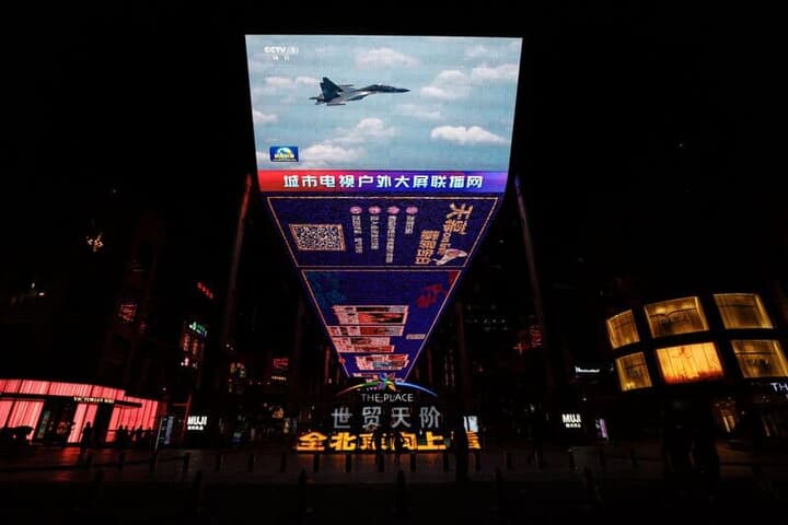 ショッピング街のモニターに表示される軍事演習の映像
