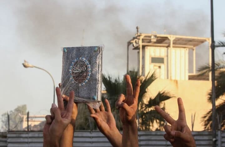 コーランをかざすイラクのデモ参加者