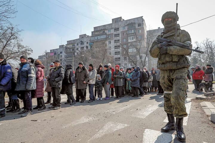 配給を待つ市民と警戒に当たるロシア兵（昨年3月、マリウポリで）