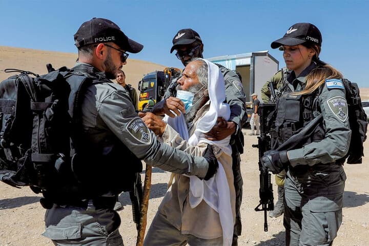 ヨルダン川西岸でイスラエルの警察ともみ合うパレスチナの老人　MUSSA QAWASMAｰREUTERS