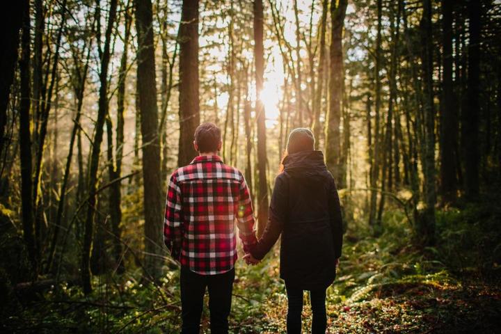 couple-holding-hands-in-the-forest-picture-id512633874.jpg
